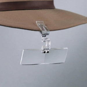 Flip Focal Clip-On Magnifier clipped to a hat brim with its clear rectangular lens flipped down